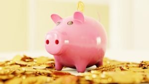 Piggy bank on top of coins. non-financial assets.