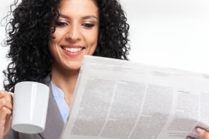 woman reading newspaper; IRS rule 7702 updates