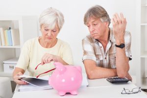 Senior couple looking at financial statements. Should you take social security early and invest it?